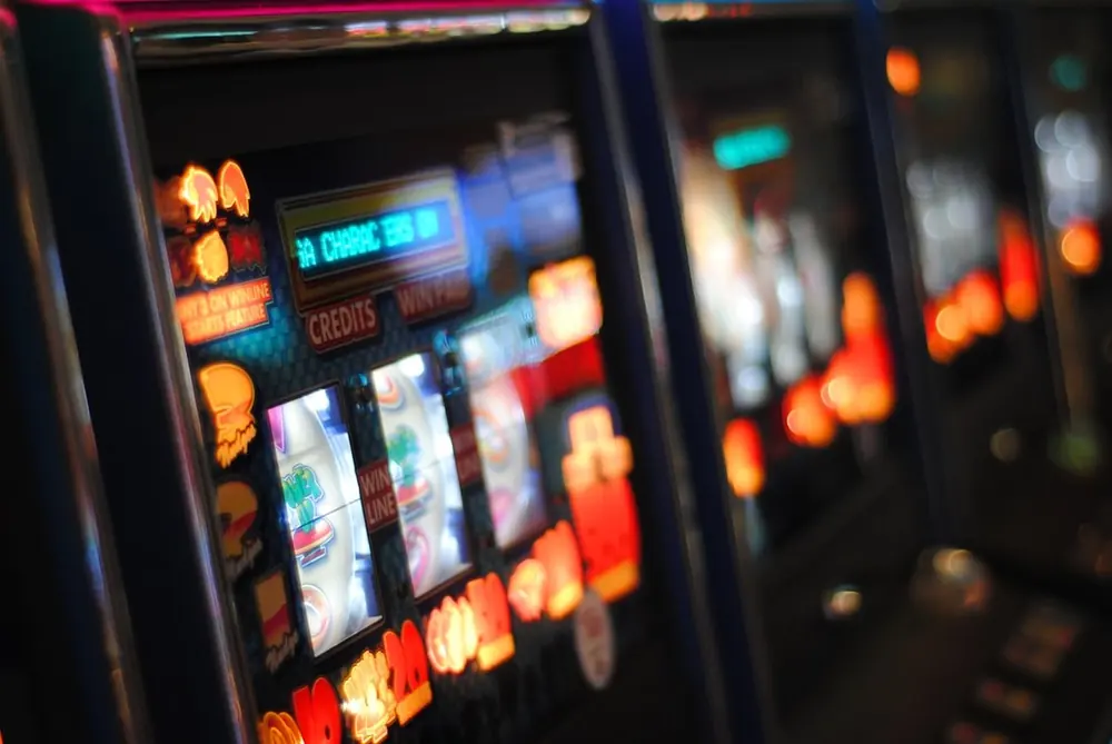 Deretan mesin slot berwarna warni di lantai kasino