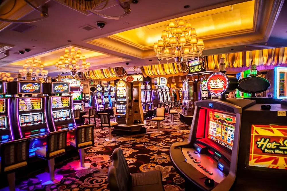 Deretan mesin slot dengan layar menyala di lantai kasino