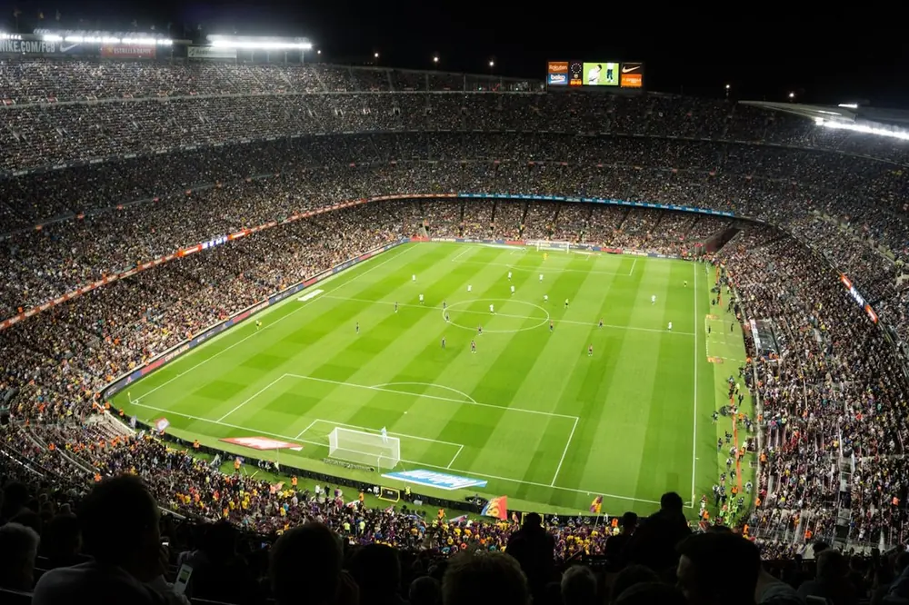Stadion sepak bola dengan lampu sorot menyala malam